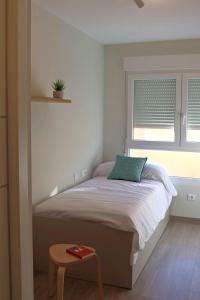 a small bedroom with a bed and a window at Apartments in Vimianzo, The Heart of Costa da Morte in A Coruña