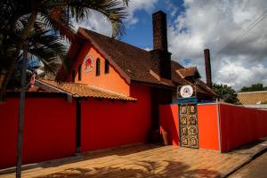 ein rotes und orangefarbenes Gebäude mit einer Palme in der Unterkunft Caminho do Sol Pousada in Chapada dos Guimarães