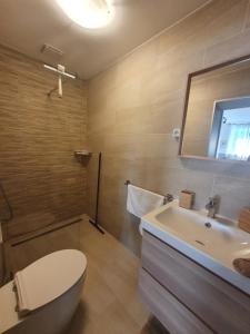 a bathroom with a toilet and a sink and a tub at Harmony apartments in Portorož