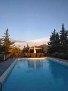 a swimming pool with a gazebo in the background at Agriturismo La Provenca in Chianciano Terme