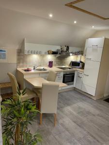 a kitchen with white appliances and a table and chairs at Ferienwohnung Meiwes in Hövelhof