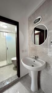 a bathroom with a sink and a mirror and a toilet at Eftelya Apart in Oludeniz