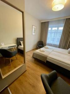 a hotel room with a bed and a mirror at Kamieniczka in Nidzica