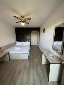 a bedroom with a bed and a ceiling fan at Pensiunea Mac in Vama Veche