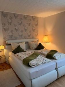 a bedroom with a white bed with pillows on it at FeWo mit Weser-Fernblick in Hehlen