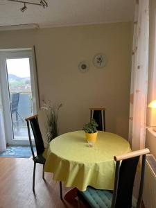 a dining room table with a yellow table cloth on it at FeWo mit Weser-Fernblick in Hehlen