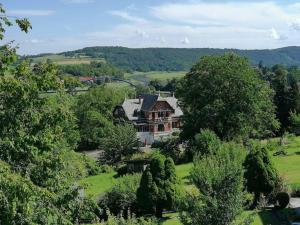 a large house in the middle of a field with trees at FeWo mit Weser-Fernblick in Hehlen