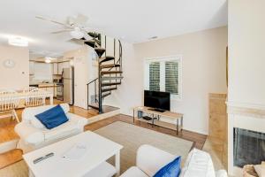 a living room with a spiral staircase and a living room at Scarborough Village - 245 Country Club Dr, Unit #608 in Rehoboth Beach