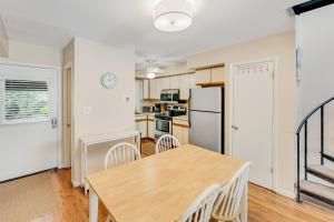 a kitchen and dining room with a wooden table and chairs at Scarborough Village - 245 Country Club Dr, Unit #608 in Rehoboth Beach