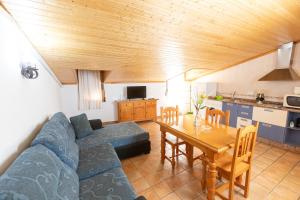 a living room with a blue couch and a table at Alojamiento Rural Arco Iris in Arroyo Frio