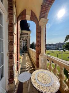 a balcony with an archway and a table at La Villa L'Argentine in Cabourg +26 photos
