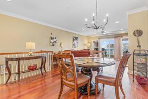 a dining room and living room with a table and chairs at Croatan Surf Club by KEES Vacations in Kill Devil Hills