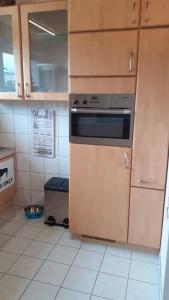 a kitchen with wooden cabinets and an oven at Ferienwohnung Silk in Niederkrüchten