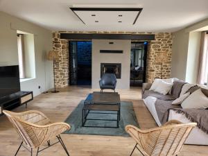 a living room with a couch and a table and chairs at Gîte le jardin Médicis avec jacuzzi et sauna privatifs in Trédion