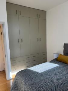 1 dormitorio con 1 cama y armario blanco grande en Central Chelsea 1 Bedroom, en Londres
