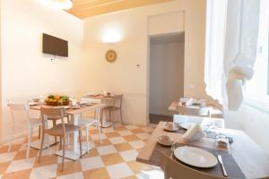 a dining room with tables and chairs and a television at B&B Handy Palermo in Palermo