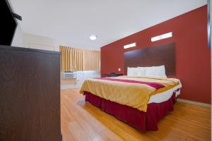 a bedroom with a large bed with a red wall at Mojave Hotel in Mojave