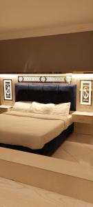 a bed with a black headboard in a room at فندق كلاسيك in Aqaba