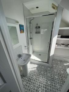 ein Bad mit einer Dusche und einem Waschbecken in der Unterkunft Bescot House Bramble Hill Bude 4 bed det house in Bude