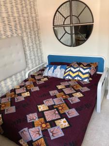 a bed with a quilt on it in a bedroom at Chandra House in Swindon