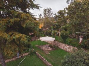 een uitzicht op een tuin met een witte tent bij Cabaña Kinti Q'umir Umiña en Kinti Wasi in Los Baños del Inca