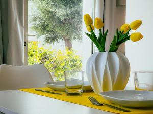 stół z wazonem z żółtymi kwiatami w obiekcie Villa Ada Olbia w mieście Olbia