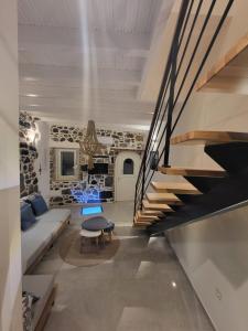a staircase in a living room with a couch and a table at Spiliani View in Mandrakion
