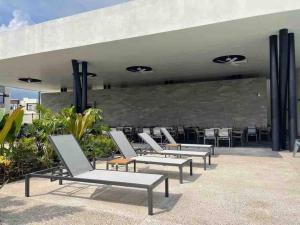 a row of lounge chairs sitting under a building at Casa Marfil Resid Frente Vidanta, Nvo Vallarta in Jarretadera