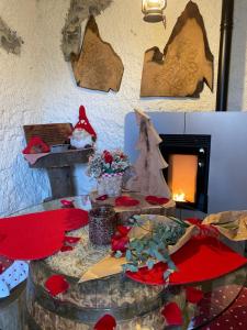 um quarto com uma mesa com flores vermelhas e uma lareira em Il Roccolino em Valsecca