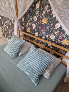 Bučovice的住宿－GLAM apartmán Bučovice，一张带枕头的床和花卉墙