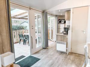 une cuisine avec une porte coulissante en verre menant à une terrasse. dans l'établissement 3 bedroom Chalets Camping Leï Suves - JoyCasa, à Roquebrune-sur Argens