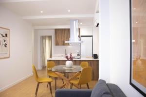 een keuken en eetkamer met een tafel en stoelen bij Apartamentos Fleming in Albacete