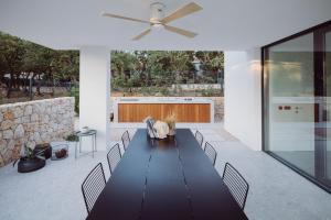 a dining room with a table and chairs and a ceiling fan at D-Tree HOUSE private heated pool in Potocnica