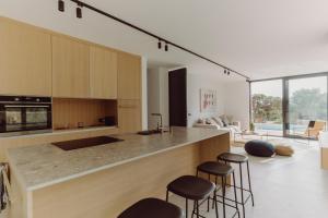 a kitchen with a counter and stools in a room at D-Tree HOUSE private heated pool in Potocnica