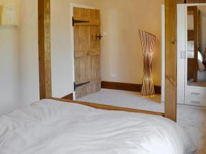 a bedroom with a bed with a wooden frame at Little Hoot in Baslow
