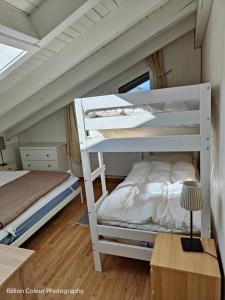two bunk beds in a room with a desk at Haus Opal Wohnung Nr. 31 in Grächen