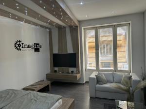 een woonkamer met een bank en een tv bij Imagine Budapest Premium Apartment in Boedapest