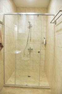 a shower with a glass door in a bathroom at Trimaya apartment - comfort in the top city center in Varna City