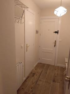 um corredor com uma porta branca e um piso de madeira em Duplex con vistas fantásticas em Monachil