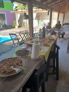 a long wooden table with food on top of it at Pousada Carambu in São Francisco do Sul