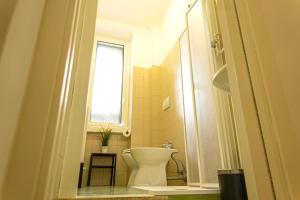 La salle de bains est pourvue de toilettes et d'une fenêtre. dans l'établissement CityFlat Guest House, à Bari