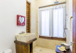baño con lavabo y aseo y ventana en DK Luxury Ocean Front Villa - Adults Only by Baleine Group en Holbox Island