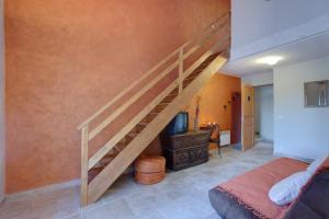 a staircase in a bedroom with a bed and a tv at La Ferme Du Midi in Piolenc