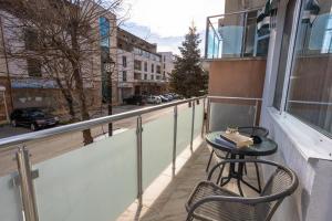 un balcone con tavolo, sedie e una strada di Guest House Desi a Balchik
