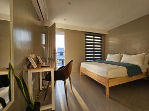 1 dormitorio con 1 cama y escritorio con silla en Spacious 5-bedroom, 4-bath townhouse in Legazpi City, en Legazpi