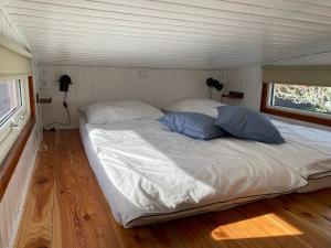 1 dormitorio con 1 cama con 2 almohadas azules en Tiny House 300 Meter vom Zentrum entfernt, en Eberswalde