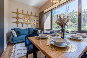 a dining room with a table and a blue couch at Piaseckiego Residence SPA in Zakopane