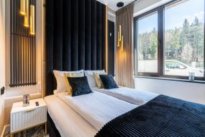 a bedroom with a large bed and a large window at Piaseckiego Residence SPA in Zakopane