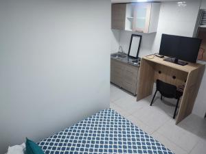 1 dormitorio con escritorio, TV y un deskicteterictetericter en Hotel torre 15, en Bogotá