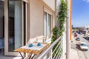 a table on a balcony with a view of a street at La Casa di Adalgisa in Fasano